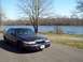 1999 Mercury Grand Marquis - Dark colored 1999 Mercury Grand Marquis parked near a body of water on a clear day.