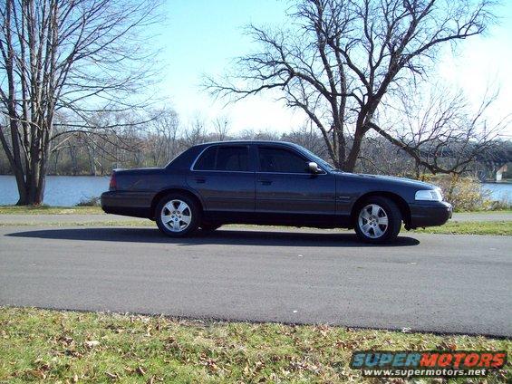 1999 Mercury Grand Marquis parked on the side of the road near a body of water