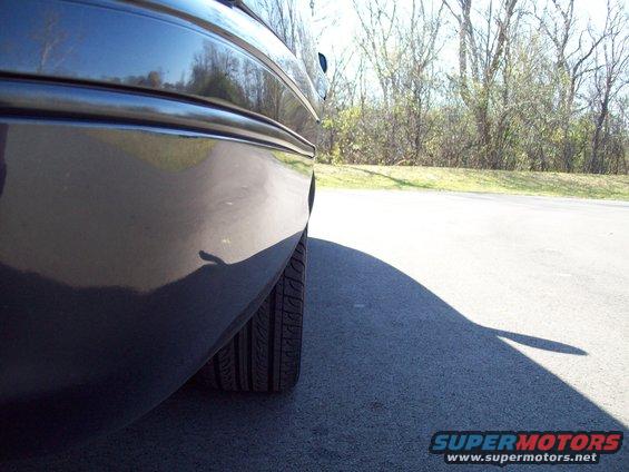 Dark sedan rear quarter panel and tire, side view