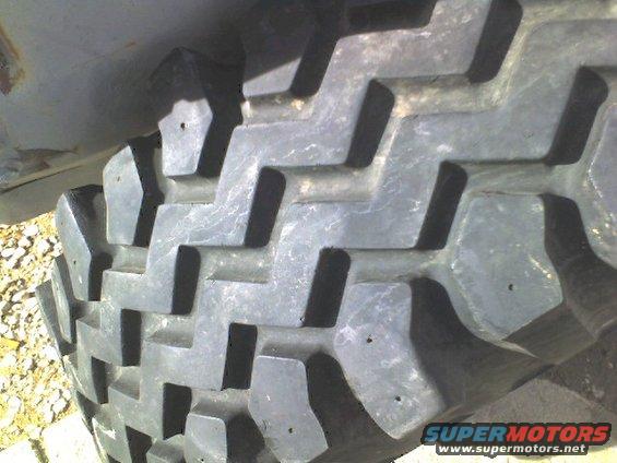 Close-up of a tire tread with a "SUPERMOTORS" logo visible
