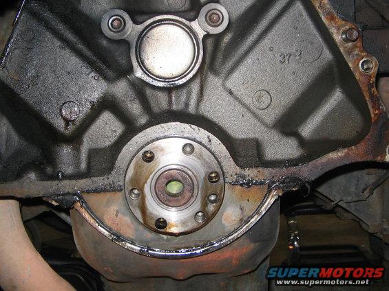 Engine block rear seal area with oil pan and flywheel housing visible. Casting number '37' is visible