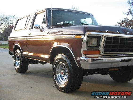 Brown 1978 Ford Bronco with chrome trim and aftermarket wheels, viewed from the front three-quarter angle