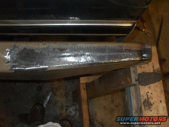 Close-up of a vehicle bumper with grinding marks from repair work