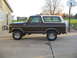 1978 Ford Bronco - Side view of a 1978 Ford Bronco with a two-tone paint scheme and spare tire on the back.