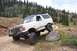 1990 Ford Bronco - This white 1990 Ford Bronco navigates a challenging rocky terrain on a mountain trail, its off-road capabilities.