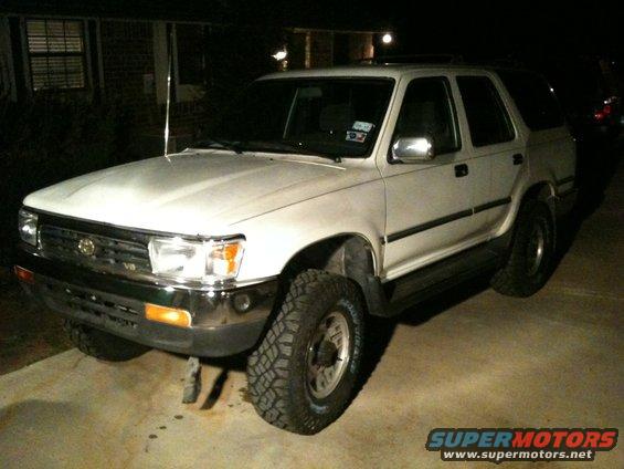 White 1993 Toyota 4Runner SUV with aftermarket tires, chrome bumper, and roof rack, viewed from a 3/4 front angle