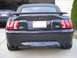 2001 Ford Mustang - Rear view of a black Ford Mustang GT convertible with a spoiler and dual exhaust pipes.