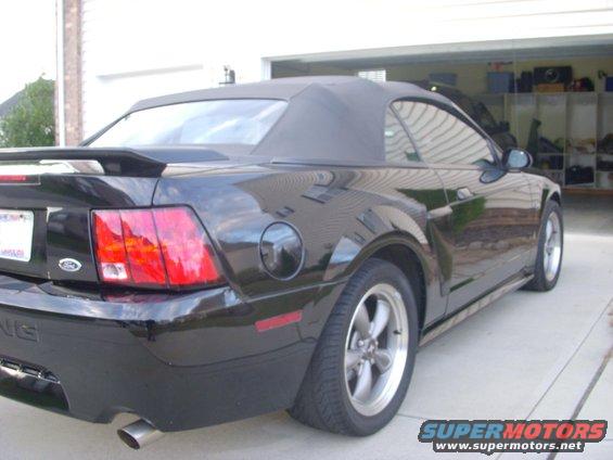 Black 2001 Ford Mustang convertible, rear 3/4 view, parked in driveway