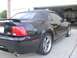 2001 Ford Mustang - Rear view of a black 2001 Ford Mustang convertible parked in front of a garage.