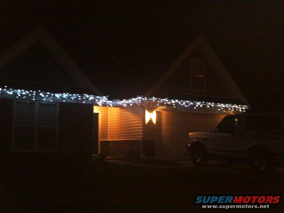 1987 Ford Bronco parked in front of a house with Christmas lights