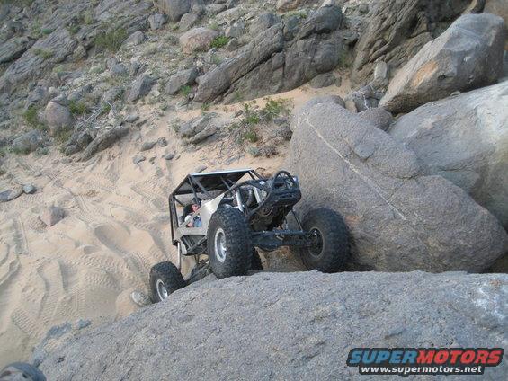 off-road buggy climbing over rocks and sand