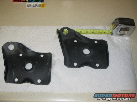 Two black metal brackets and a tape measure on a paper towel