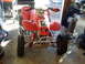 1987 Honda 250 R - Front view of a red ATV parked indoors with various items in the background.