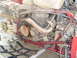 1987 Honda 250 R - Close-up view of an ATV's engine and frame, showing mechanical details and red tubing.