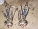 1987 Honda 250 R - Two front suspension assemblies with shocks and A-arms are laid out on a concrete floor.