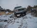 1989 Ford Bronco - A white Ford Bronco navigates a challenging snowy terrain with rocky obstacles.