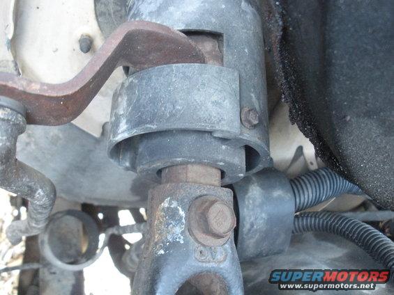 Close-up of a rusty metal bracket attached to a steering column assembly