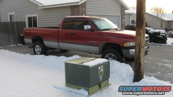 Red and silver 1997 Dodge 2500 pickup truck in snow