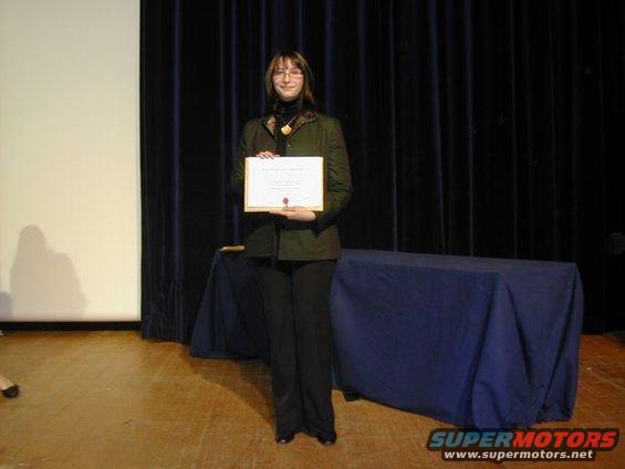 Woman holding a certificate on stage