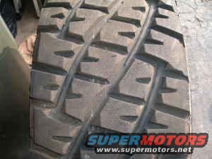 Close-up of a tire tread with "SUPERMOTORS www.supermotors.net" text at the bottom