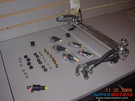 Fuel injectors and fuel rail assembly laid out on a table