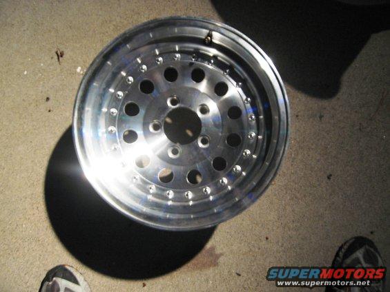 Aluminum wheel with multiple circular cutouts and small bolt holes