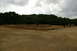 1986 Ford Bronco - An outdoor track for remote control cars is set up with dirt and black borders, under a cloudy sky.