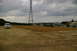 1986 Ford Bronco - A white van sits on a dirt lot under a cloudy sky, with a large power line tower visible.