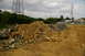 1986 Ford Bronco - A construction site with piles of debris and a large power line tower under a cloudy sky.