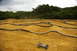 1986 Ford Bronco - Remote control cars navigate a challenging dirt track with multiple obstacles and turns.