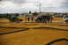 1986 Ford Bronco - A group of people observe an RC track with various vehicles and equipment present under a cloudy sky.