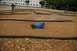 1986 Ford Bronco - A remote control car races on a dirt track with spectators in the background.
