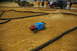 1986 Ford Bronco - RC car racing on a dirt track with spectators in the background.