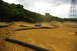 1986 Ford Bronco - A remote control buggy races around a dirt track, creating a dust cloud under a cloudy sky.