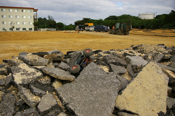Upside-down remote control rock crawler on asphalt rubble