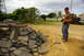 1986 Ford Bronco - A person operates a remote control car near a construction debris pile with a tracked vehicle in the distance.