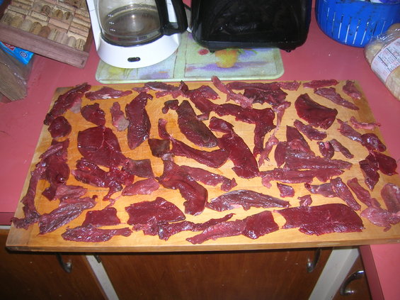 Raw meat slices arranged on a wooden cutting board