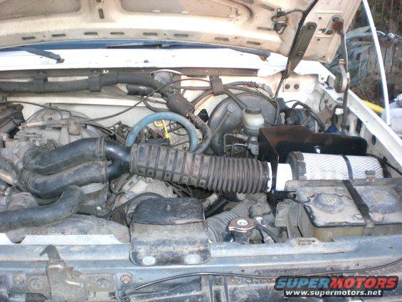 Engine bay with air intake and filter. Supermotors.net logo visible