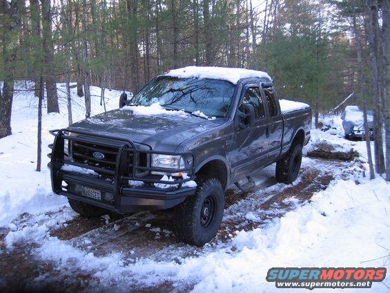 Gray 2003 Ford F-350 pickup truck with a brush guard parked in the snow