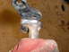 1987 Honda 250 R - A metal bracket shows recent welding work, held by a gloved hand.
