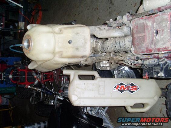ATV engine with large auxiliary fuel tank attached. IMS logo on tank