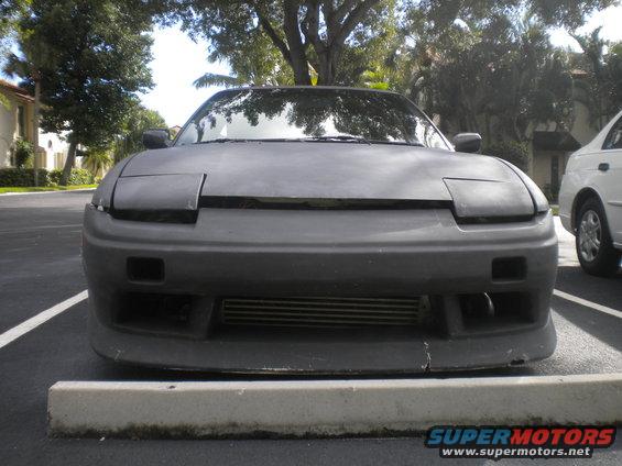 1991 Nissan 240SX front view, pop-up headlights up, aftermarket front bumper with intercooler visible