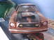 1978 Ford Mustang II - A toy car with a Ford badge on the windshield sits on a surface with other items.