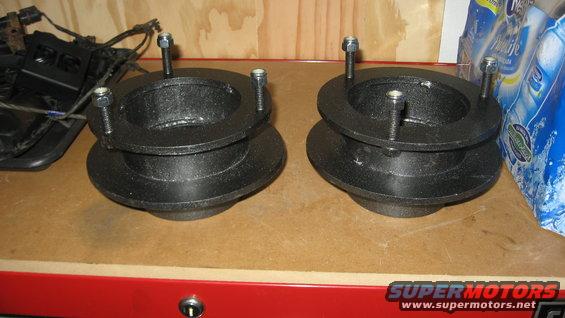 pair of black metal suspension lift spacers with bolts