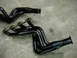 1978 Ford Bronco - Two black exhaust headers are shown on a concrete surface.