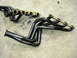 1978 Ford Bronco - A pair of black exhaust headers are shown on a concrete surface.