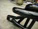 1978 Ford Bronco - Close-up view of black metal exhaust headers, showing their tubular construction and mounting points.