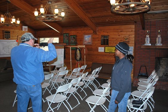 Interior of a wooden room with chairs and two people