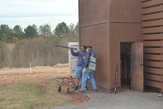 Two men practice shooting at a clay pigeon range