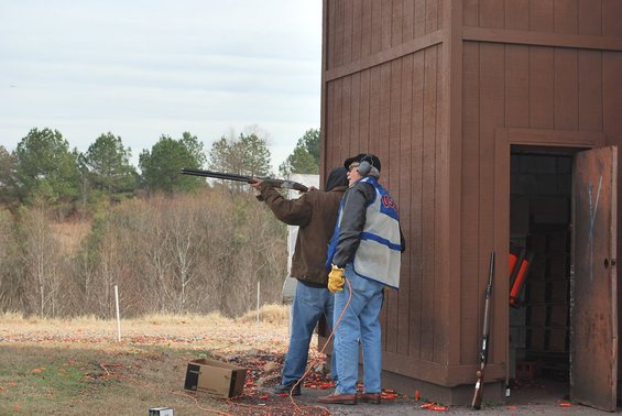 Two men practice shooting at a clay pigeon range